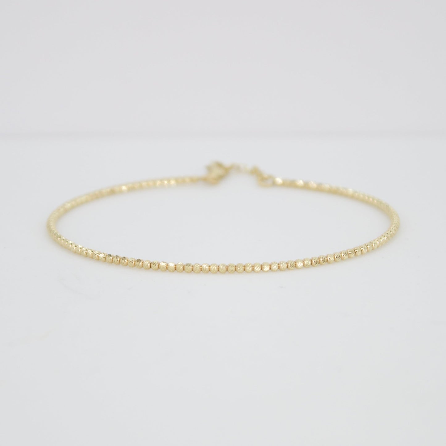 Pulsera rígida de bolitas en oro amarillo 14k.