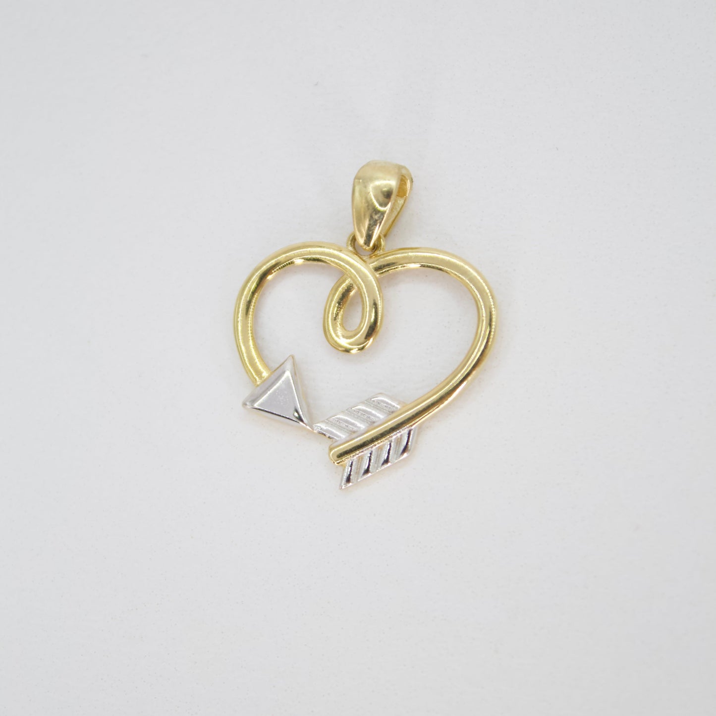 Dije corazón flecha en oro combinado 14k.