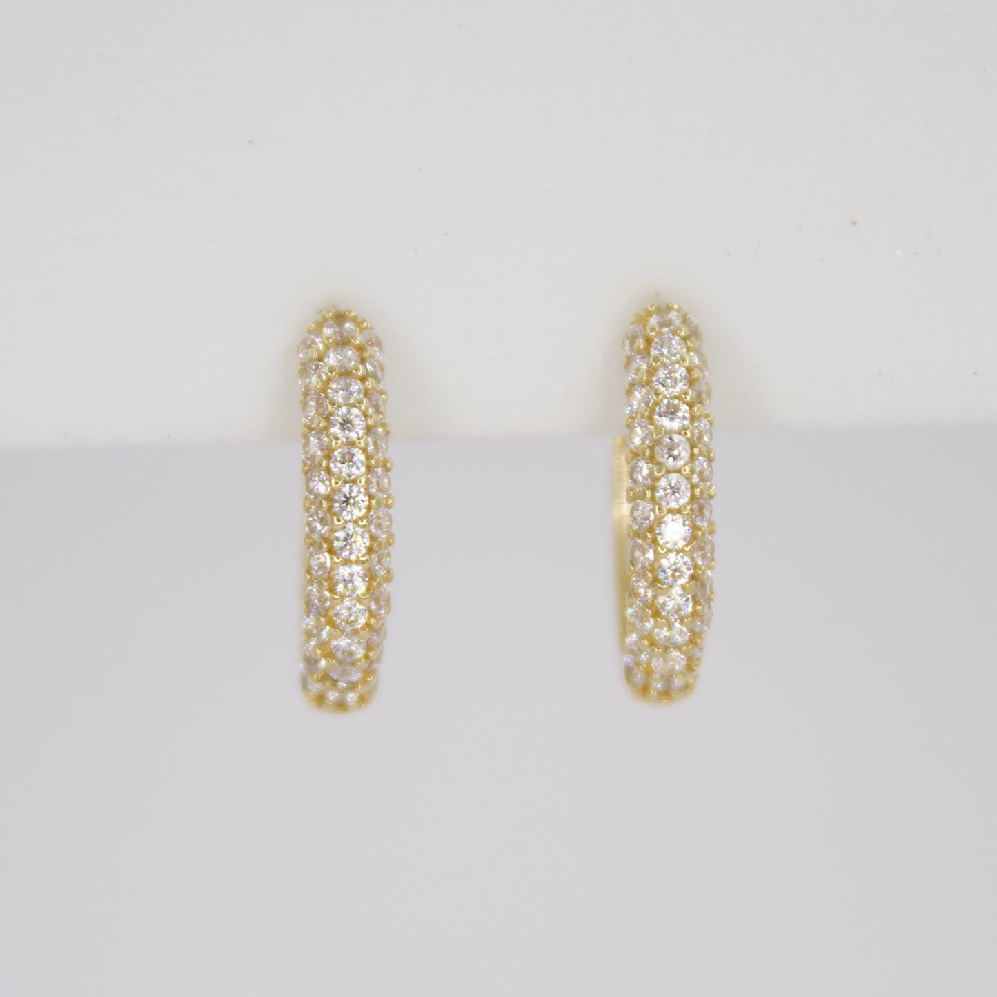 Aretes Huggies en oro amarillo 14k con zirconias.