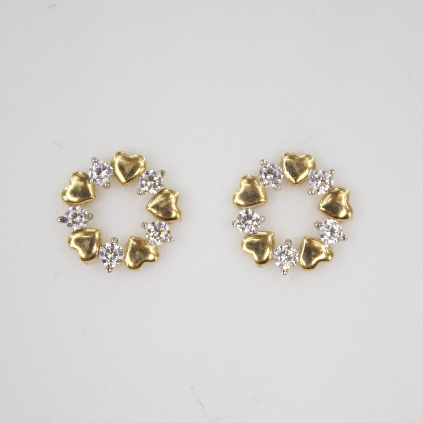 Aretes corazones en oro amarillo 14k con zirconias.